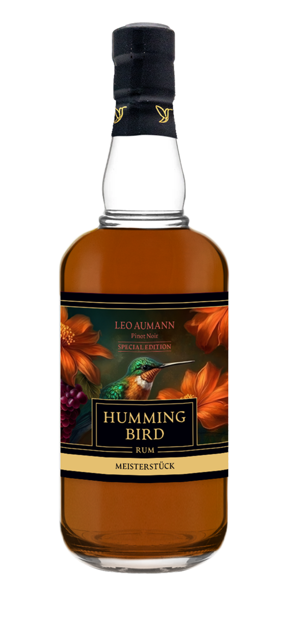 A bottle of Humming Bird Rum with a label featuring orange flowers and a colorful hummingbird.