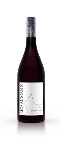 Eine Flasche Leo Aumann Pinot Noir mit weißem Etikett und goldfarbenem Verschluss auf weißer Oberfläche.